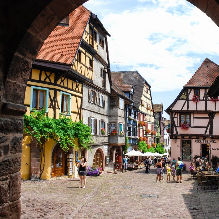 RIQUEWIHR, FRANCE - JULY 11, 2010: visitors on square of Riquewihr town. Riquewihr is commune in Alsace Wine Route region, the town belongs to the association The most beautiful villages of France